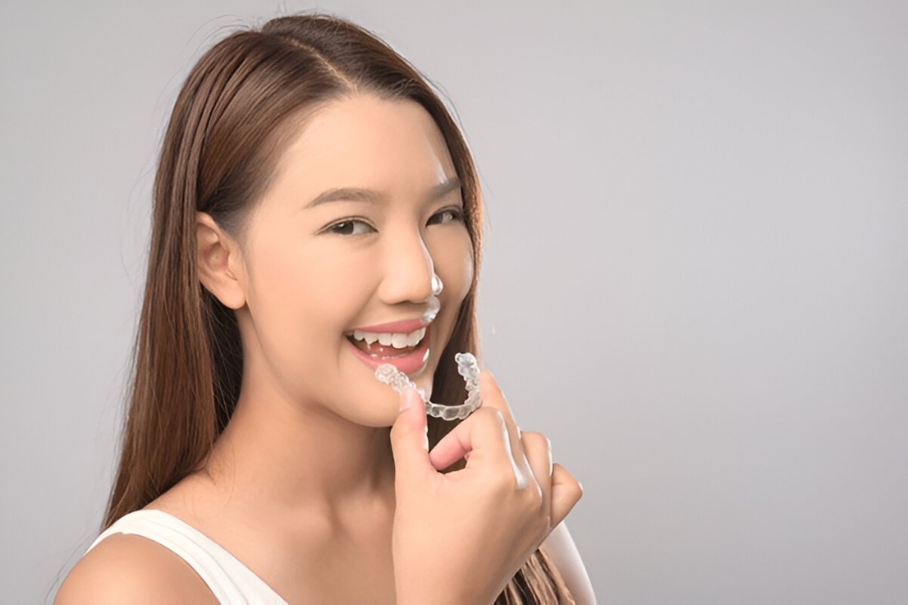 Adult patient smiling with Invisalign aligners in Vancouver